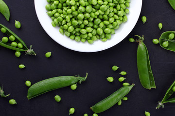 Fresh green peas on a black background