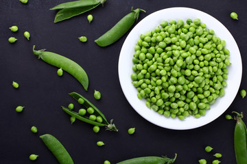 Fresh green peas on a black background