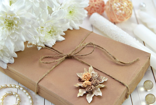 Close Up Of Gift In Brown Paper With Beautiful Flowers 
