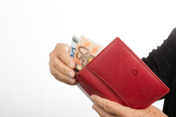 Alte Frau holt Geld aus dem Portemonnaie