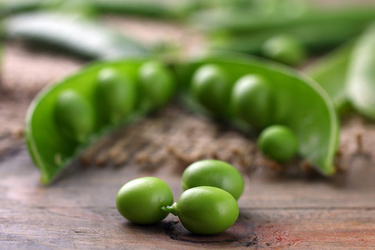 Fresh green peas on a wooden background. Peas on sacking