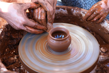 Hands working on pottery wheel