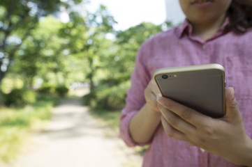 Young woman looking at a smart phone in the park
