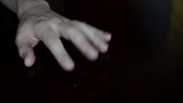 Tapping Hand on a Dark Surface