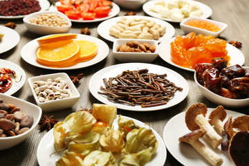 Different products on saucers on wooden table, closeup