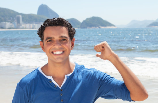 Junger Mann im blauen Shirt an der Copacabana liebt Rio