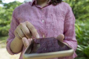 Women who have a mobile game in the park