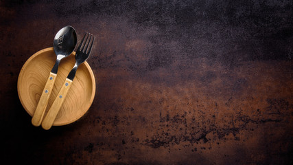 Wooden bowl ,fork and spoon on vintage background