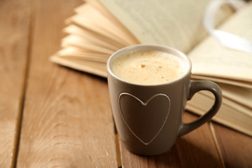 Still life with cup of coffee and book, on wooden table