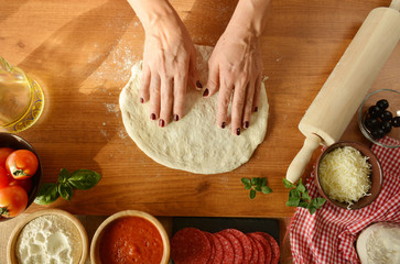Fototapeta premium woman hands cooking pizza at home
