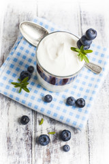 Light breakfast setup with yogurt on white wooden table