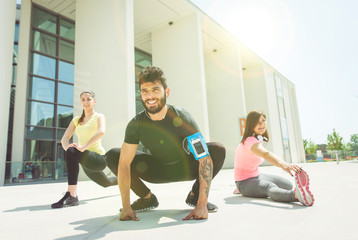 Obraz premium three urban runners preparing with stretching