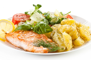 Fried salmon and vegetables on white background 