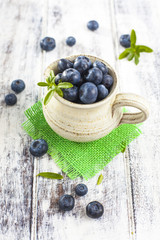 Jug of blueberries on white wooden table