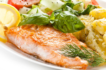 Fried salmon and vegetables on white background 