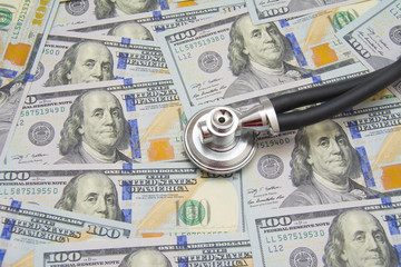 Fototapeta premium Stethoscope on money background - medical concept