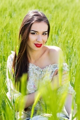 Beautiful girl at the green field of rye