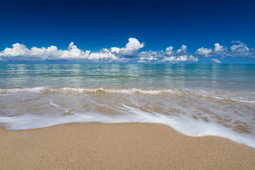 sea waves lash line impact on the sand beach under blue sky