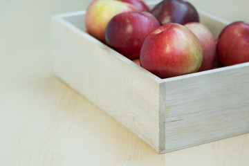 Apples in the wooden box on the table, close up