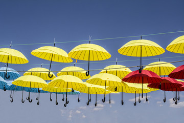colored umbrellas hanging from a rope sky background