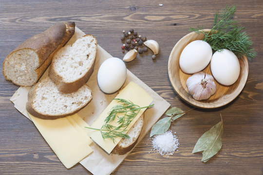Bread, eggs, cheese, vegetables and spices on wood table
