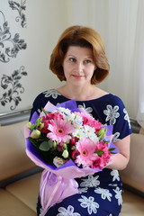 Woman with a bouquet of flowers in the room
