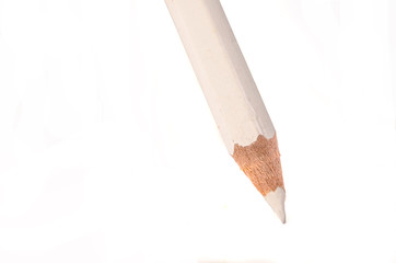 Sharpened white pencil draws a line on a white paper