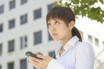 スマートフォンを見てがっかりする若い日本人女性