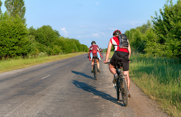 Naklejka premium Group of tourists mountain bike ride on dirt road. 