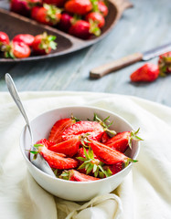 juicy red strawberry slices in a white plate, blue background, h