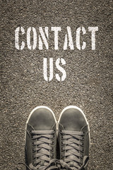 Contact Us stencil print on the asphalt road