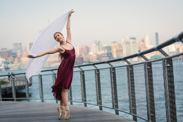 Young beautiful ballerina dancing along the New Jersey waterfront. New York.