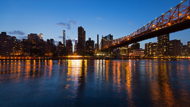 Panoramic midtown Manhattan skyline with reflections at night fr