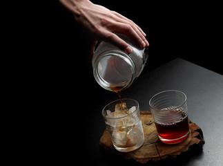 Filter coffee in glasses of hot and cold on a wooden board on dark background with copy space.