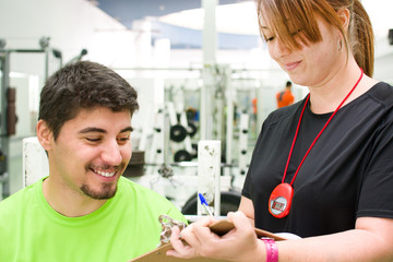 Fototapeta premium young woman making a training plan to a man at the gym