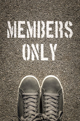 Members only stencil print on the asphalt road