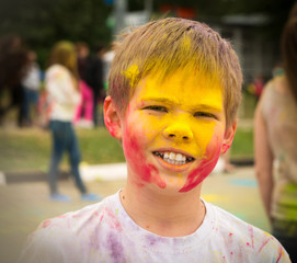 Portrait of happy child on holi color festival. Boy with colored face.