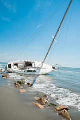 Obraz premium sailboat wrecked and stranded on the beach