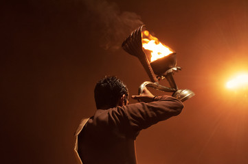 Indian priest performs religious Ganga Aarti ceremony or fire puja at Dashashwamedh Ghat in Varanasi. Uttar Pradesh