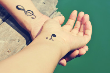 a young man with some musical symbols tattooed in his wrists