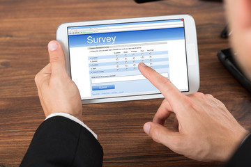 Businessperson With Mobile Phone Showing Survey Form