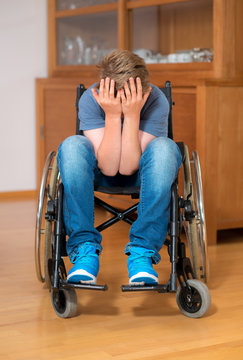 disabled boy in wheelchair is sad