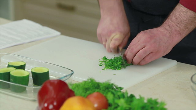 Close-up of a chef chopping parsley. Frontal shot