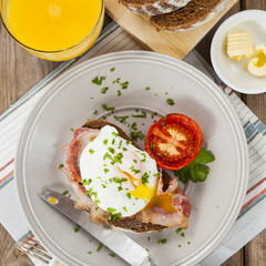 Poached egg and bacon on rye bread, healthy breakfast
