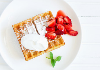 Pets (Belgian) waffles with strawberries and whipped cream.