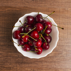 Cherries on wooden table with water drops macro background