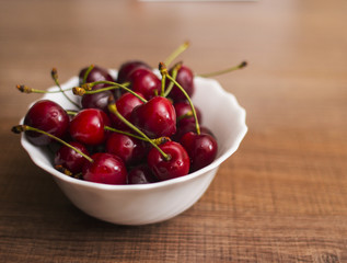 Cherries on wooden table with water drops macro background