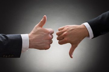 Businesspeople Hands Showing Thumb Up And Thumb Down