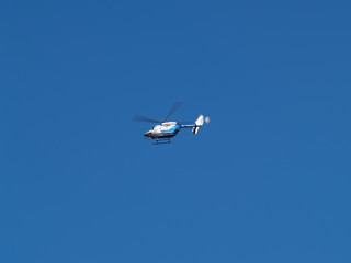 Small Medical Helicopter In Flight Against Blue Sky