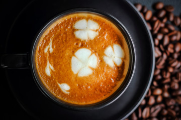 coffee in black cup with coffee beans background 